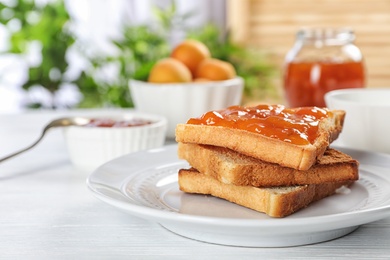 Photo of Bread with tasty apricot jam on plate