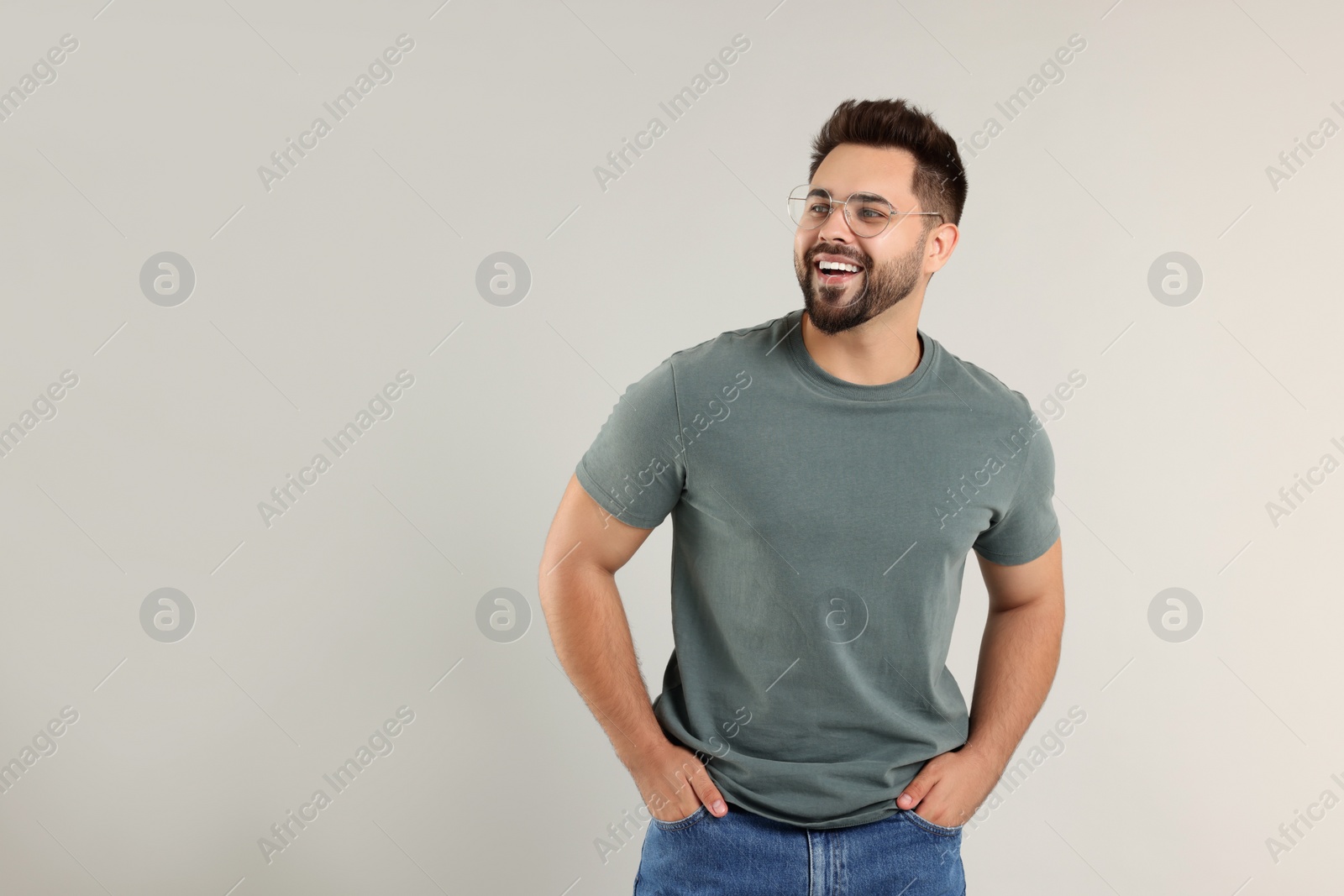 Photo of Handsome man wearing glasses on light gray background, space for text