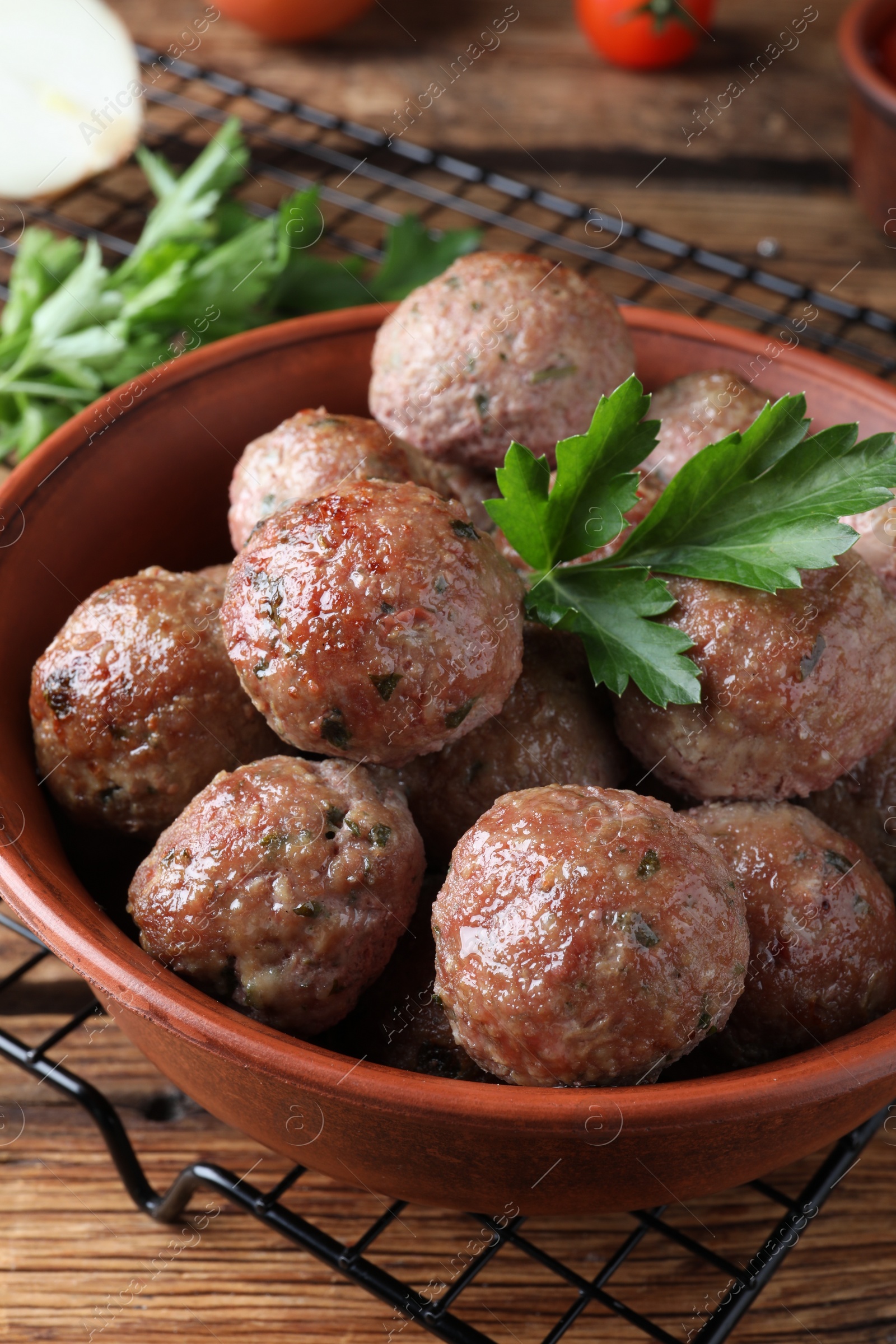 Photo of Tasty cooked meatballs with parsley on wooden table