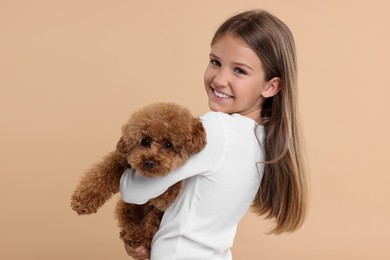 Little child with cute puppy on beige background. Lovely pet