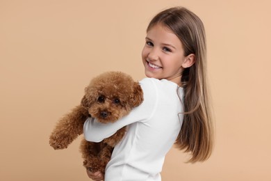 Photo of Little child with cute puppy on beige background. Lovely pet