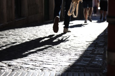 Photo of People walking on paving stone outdoors, closeup