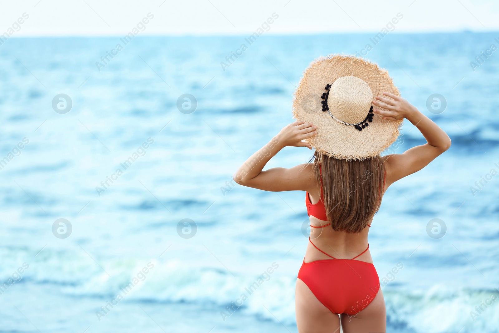 Photo of Attractive young woman in beautiful one-piece swimsuit on beach