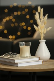 Side table with books and decor near sofa in room, closeup