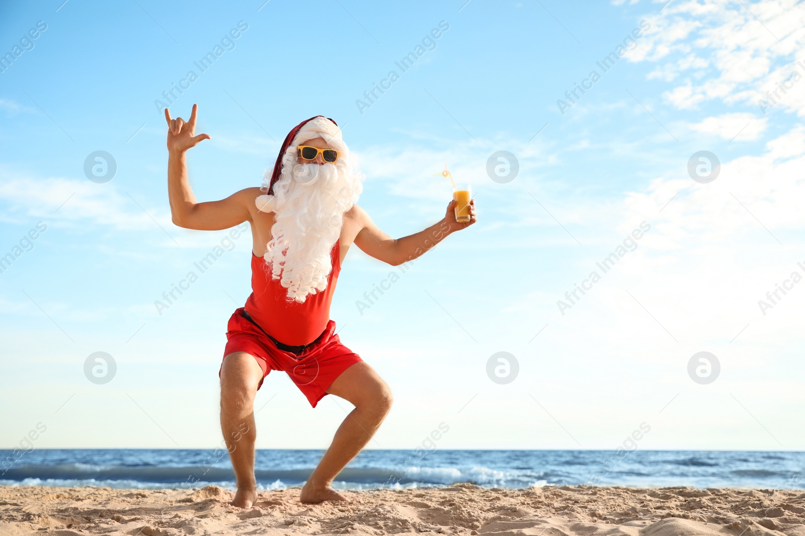 Photo of Santa Claus with cocktail having fun on beach, space for text. Christmas vacation