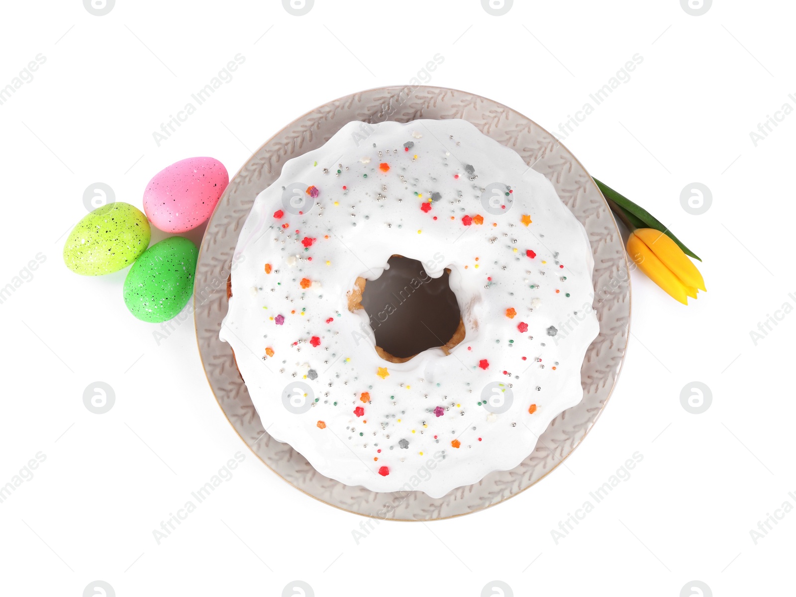 Photo of Easter cake with sprinkles, painted eggs and tulip isolated on white, top view