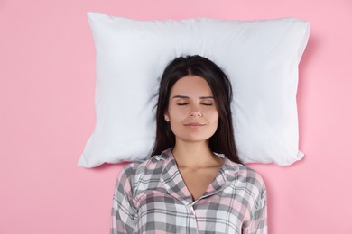 Photo of Young woman sleeping on soft pillow against pink background