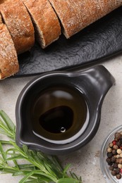 Saucepan of organic balsamic vinegar with oil, spices and bread slices on beige table, flat lay