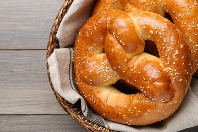 Photo of Basket with delicious pretzels on wooden table, closeup