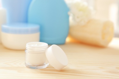 Photo of Jar with body care cream on table