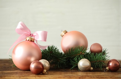 Beautiful Christmas balls on wooden table against light background