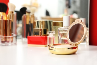 Photo of Luxury compact powder on dressing table, space for text. Interior element