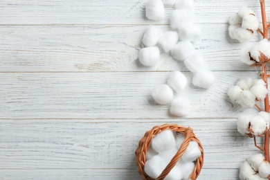 Flat lay composition with cotton balls, flowers and space for text on white wooden background