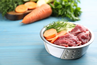 Photo of Natural pet food in feeding bowl on light blue wooden table, closeup. Space for text