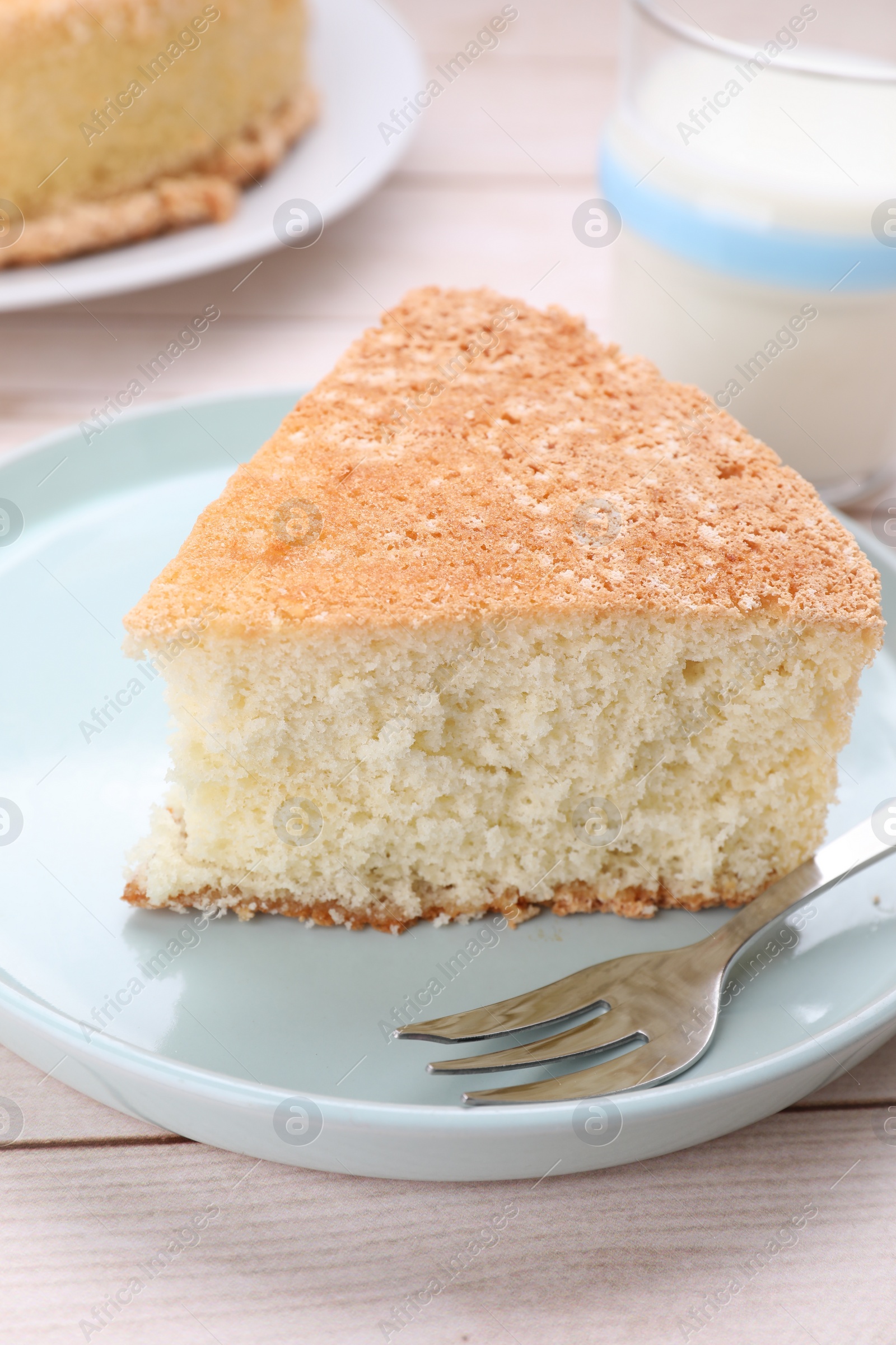Photo of Piece of tasty sponge cake on white wooden table, closeup