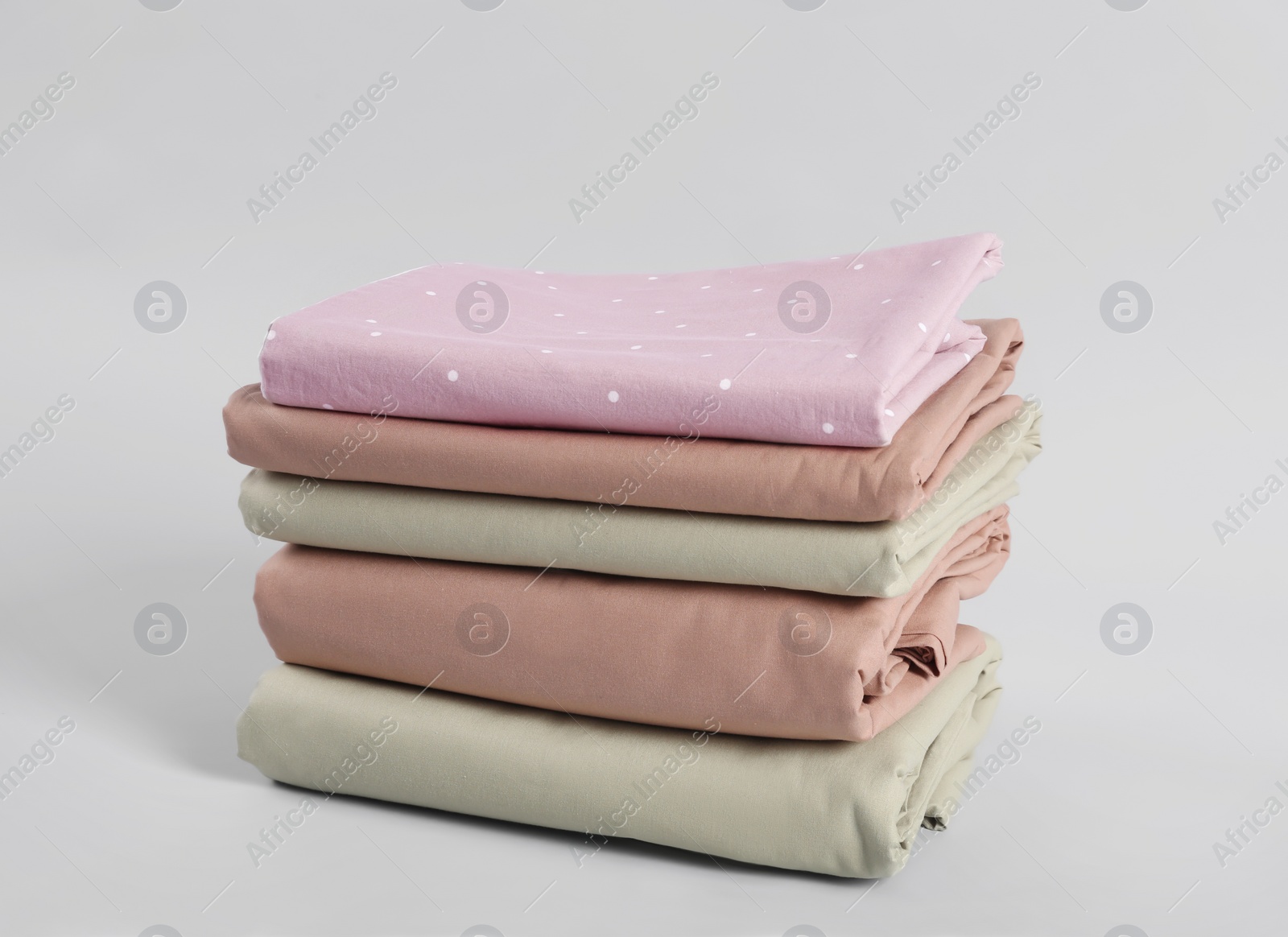 Photo of Stack of clean bed sheets on white background