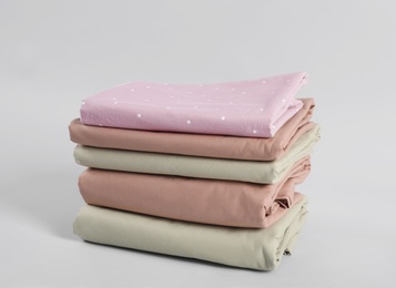 Stack of clean bed sheets on white background