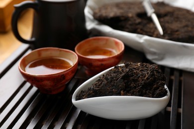 Aromatic pu-erh on wooden tray, closeup. Fermented tea