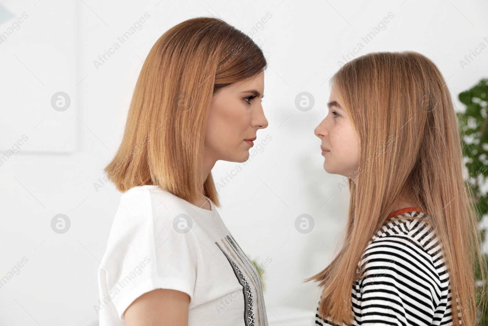 Photo of Mother and her teenager daughter looking at each other indoors