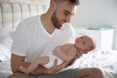 Photo of Father with his newborn son at home