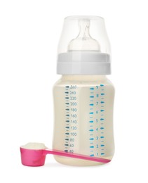 Photo of Feeding bottle with infant formula and scoop of powder on white background. Baby milk