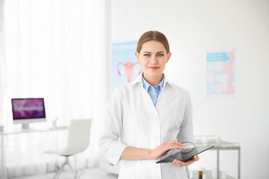 Young female doctor with tablet in modern hospital. Gynecology consultation