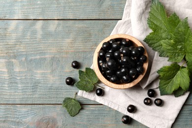 Photo of Ripe blackcurrants and leaves on wooden rustic table, flat lay. Space for text