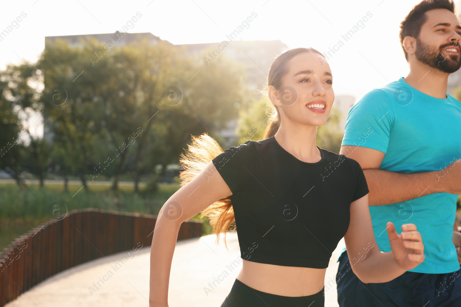 Photo of Healthy lifestyle. Happy couple running outdoors on sunny day