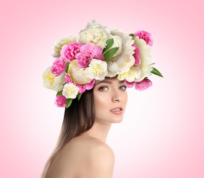 Image of Pretty woman wearing beautiful wreath made of flowers on light pink background
