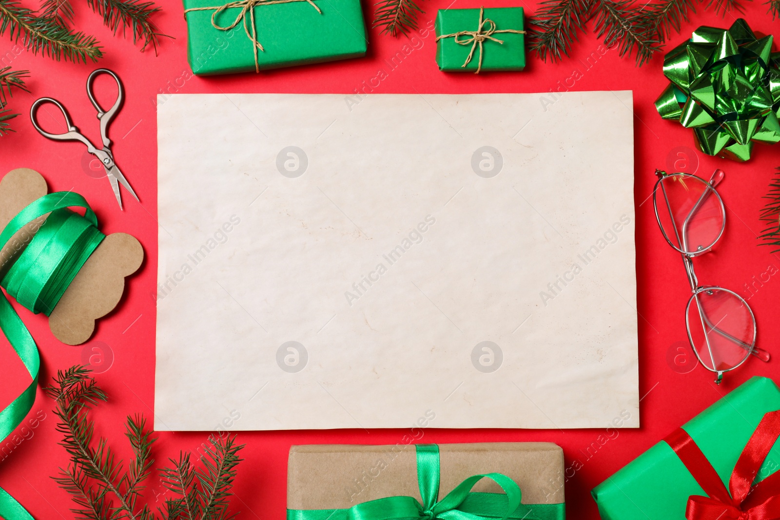 Photo of Flat lay composition with empty card and Christmas decorations on red background, space for text. Writing letter to Santa Claus