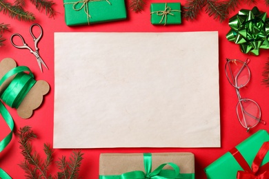 Flat lay composition with empty card and Christmas decorations on red background, space for text. Writing letter to Santa Claus