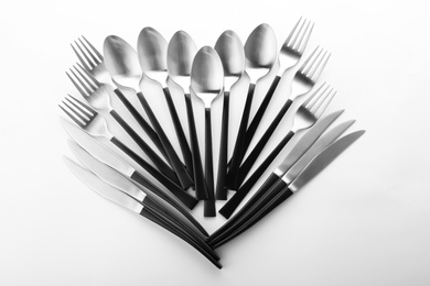 Forks, knives and spoons on white background