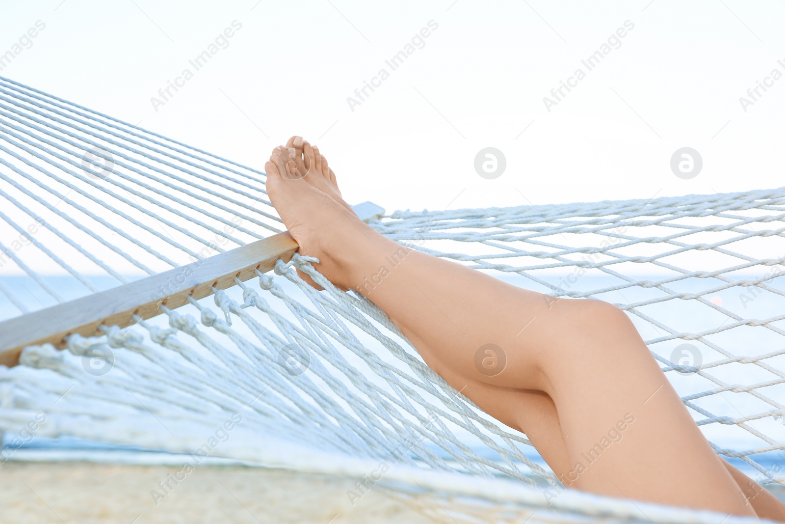 Photo of Young woman resting in hammock at seaside. Summer vacation