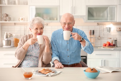 Elderly couple having breakfast in kitchen