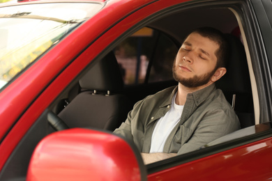 Photo of Tired man sleeping in his modern car