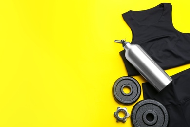 Photo of Flat lay composition with sportswear and equipment on yellow background, space for text. Gym workout