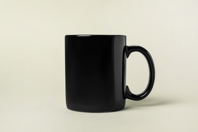 One black ceramic mug on light grey background