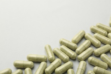 Vitamin capsules on light grey background, above view with space for text. Health supplement