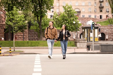 Young couple crossing street. Traffic rules and regulations