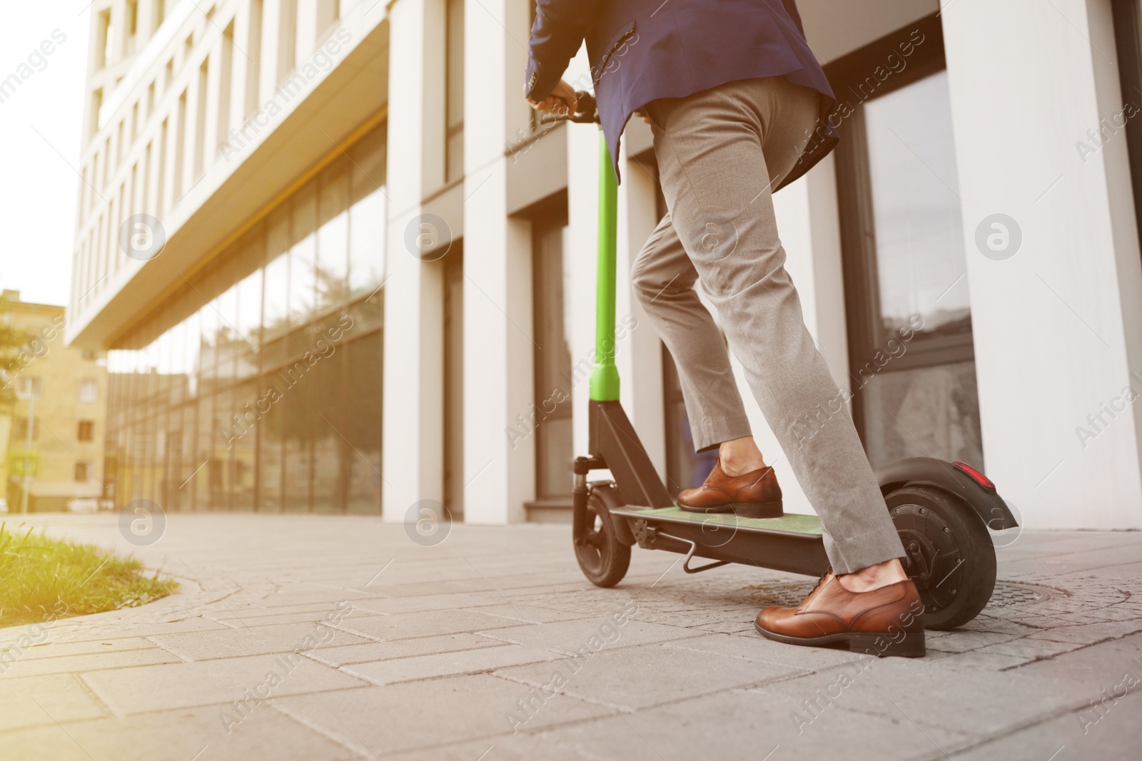 Photo of Businessman riding modern kick scooter on city street, closeup. Space for text