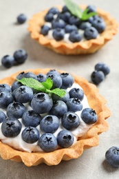 Photo of Delicious sweet pastry with berries on grey table, closeup. Space for text