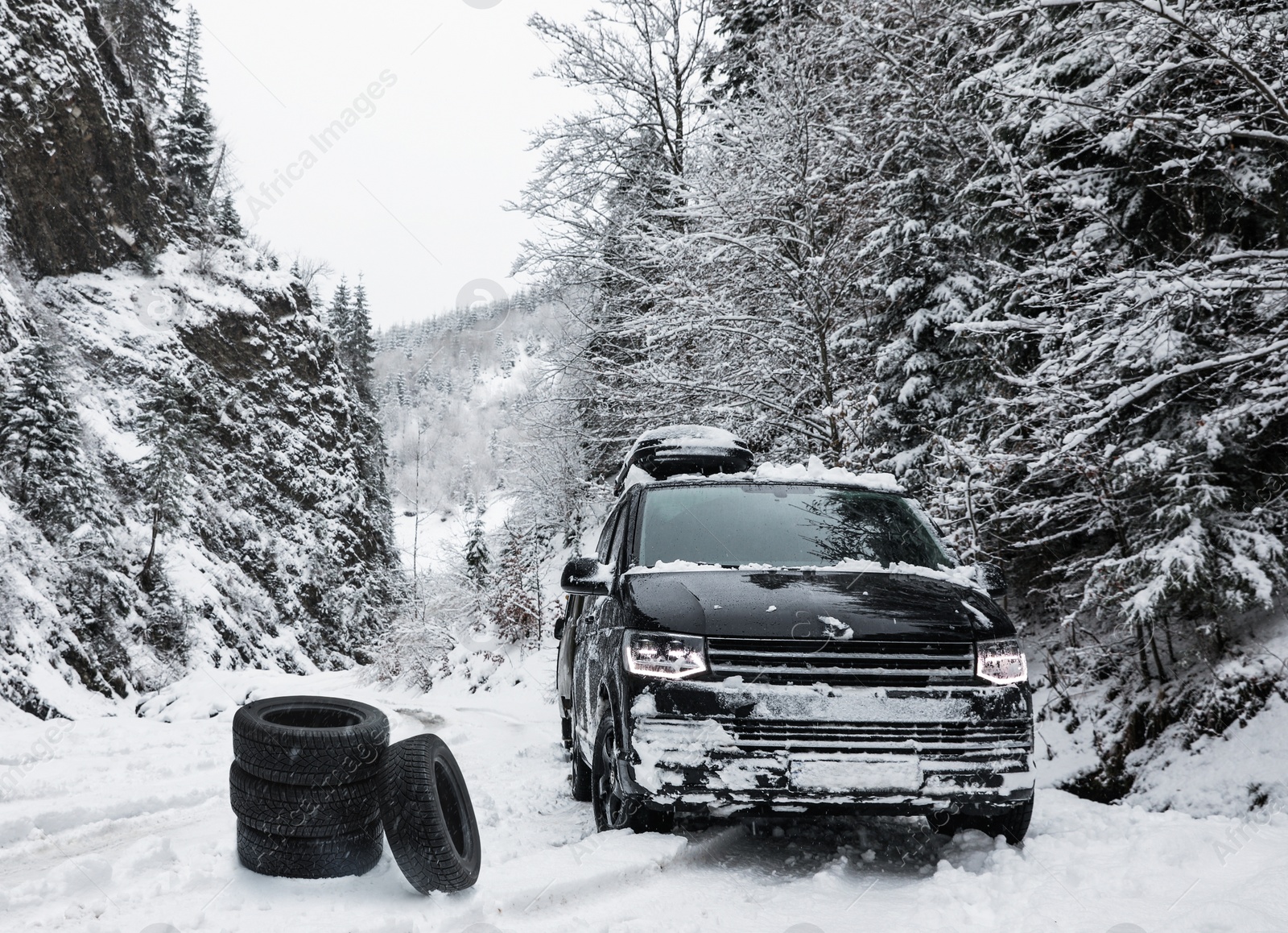 Image of Snow tires near car on road in winter