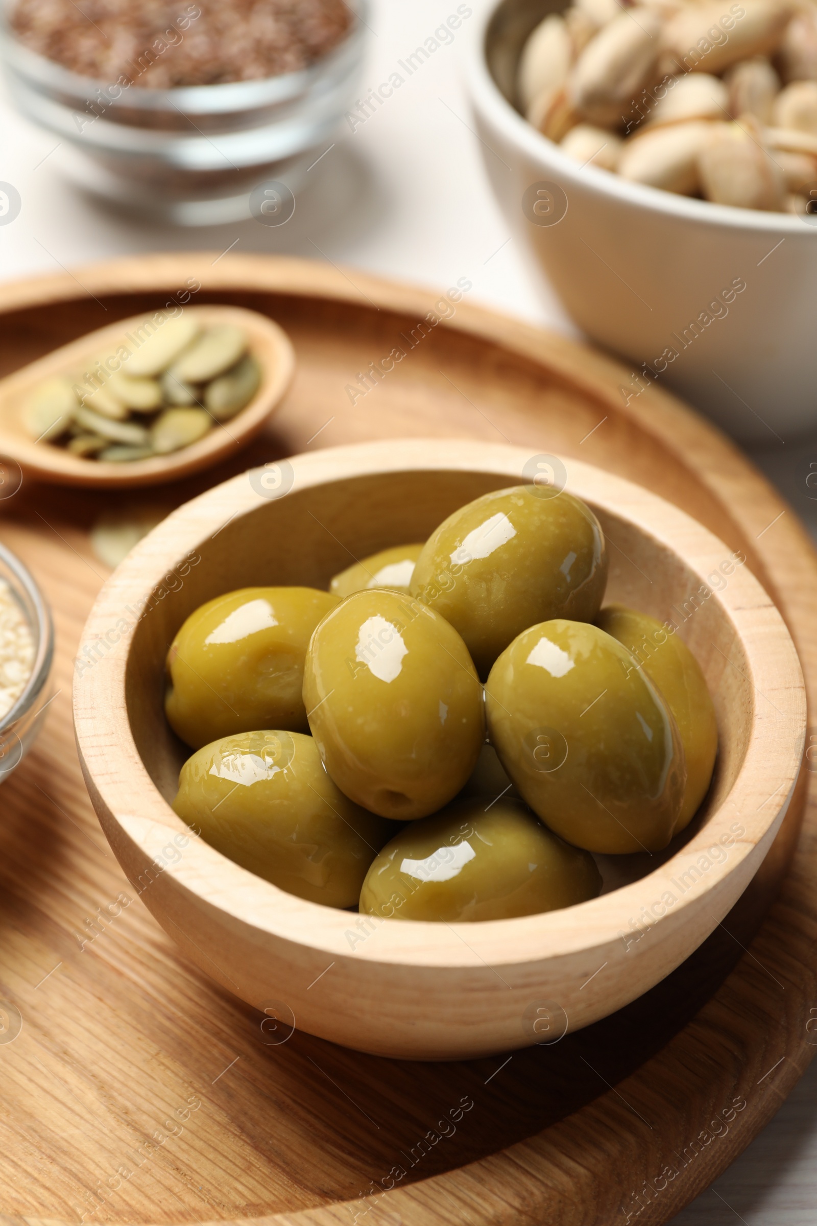 Photo of Products high in vegetable fats. Olives and seeds on table, closeup