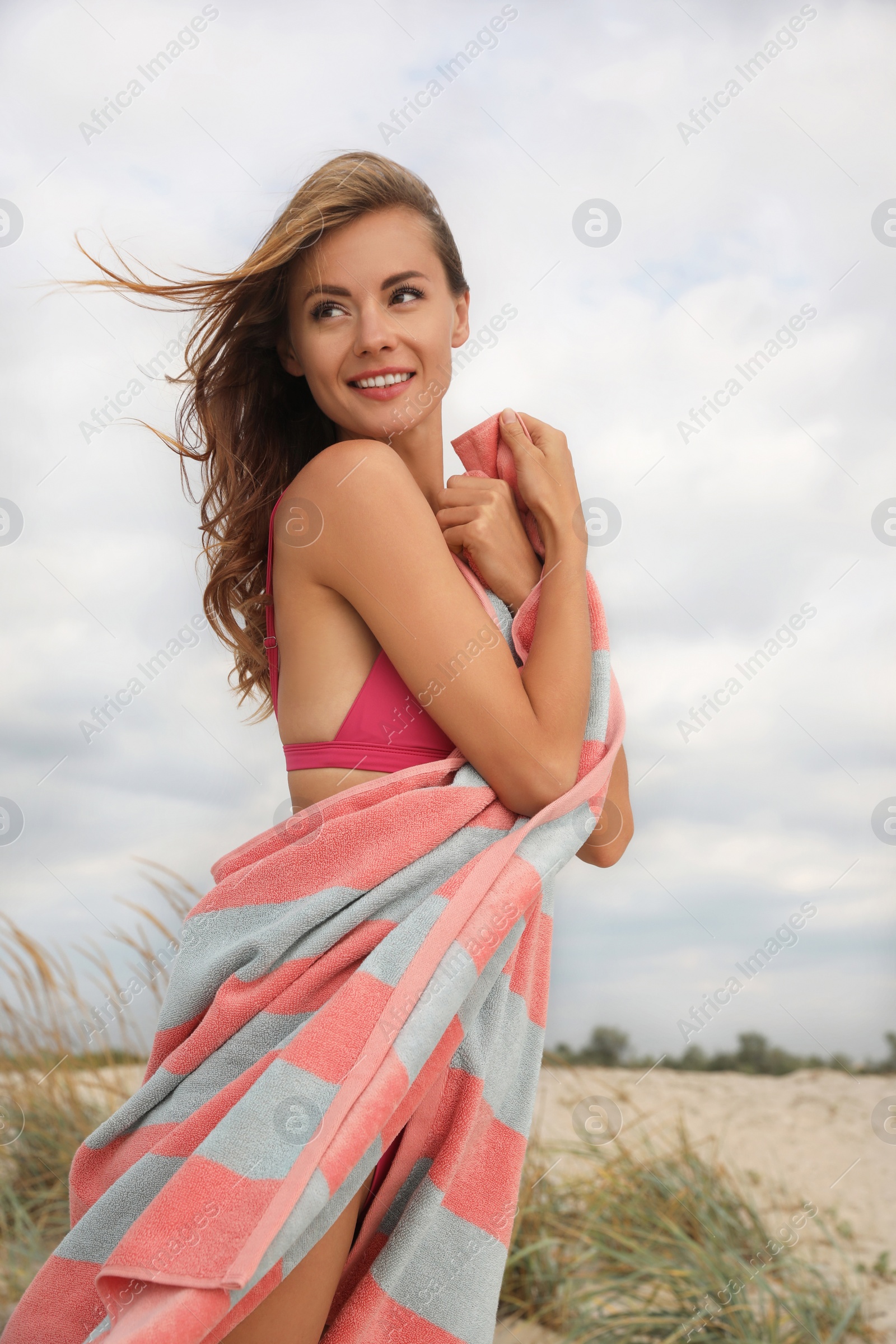 Photo of Beautiful woman with beach towel on sand