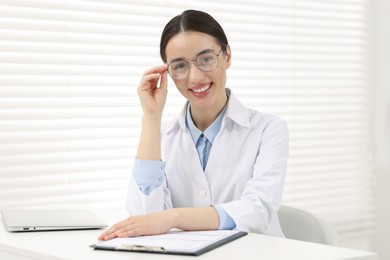 Photo of Medical consultant with glasses at table in clinic