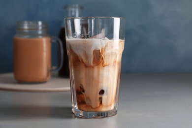 Glass with cold brew coffee and milk on table