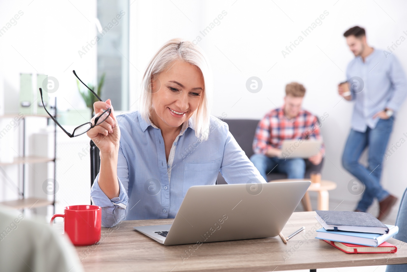 Photo of Businesswoman with colleagues working in office. Professional communication