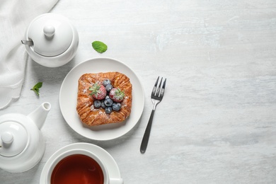 Fresh delicious puff pastry with sweet berries served on light table, flat lay. Space for text