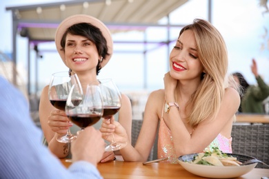 Group of friends with glasses of wine at table