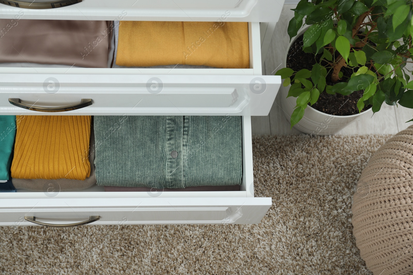 Photo of Sorting and organizing. Different folded clothes in drawer indoors, above view